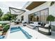 A luxurious outdoor living space with a pool, fire pit, seating, and grill area at 4103 W Knights Ave, Tampa, FL 33611