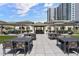 A lovely outdoor area with tables and seating surrounded by lush landscaping and an outdoor kitchen at 450 Knights Run Ave # 104, Tampa, FL 33602