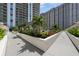 Well-maintained outdoor area featuring manicured flowerbeds and inviting walkways between modern buildings at 450 Knights Run Ave # 104, Tampa, FL 33602