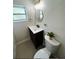 Bathroom featuring modern vanity with round mirror, window, and plants atop the toilet at 4511 Hampshire Rd, Tampa, FL 33634