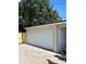View of the detached garage with closed white garage door and tan trim on a sunny day at 4511 Hampshire Rd, Tampa, FL 33634