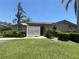 Inviting one-story home featuring lush landscaping and a well-manicured lawn on a sunny day at 4558 Morningside # 43, Sarasota, FL 34235