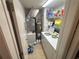 Laundry room features a washer and dryer, hot water heater, storage shelving, and assorted cleaning supplies at 4558 Morningside # 43, Sarasota, FL 34235