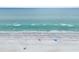 Aerial view of a wide sandy beach with clear turquoise water and people enjoying the sun at 464 20Th Ave, Indian Rocks Beach, FL 33785