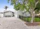 Charming gray home with a meticulously paved driveway, manicured lawn, and elegant black fencing at 464 20Th Ave, Indian Rocks Beach, FL 33785