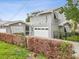 Two-story home featuring a gray exterior with a white garage door, surrounded by a well-maintained hedge at 464 20Th Ave, Indian Rocks Beach, FL 33785