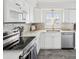 Well-lit kitchen featuring stainless steel appliances, white cabinetry, and tiled backsplash at 464 20Th Ave, Indian Rocks Beach, FL 33785