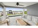Covered patio with a ceiling fan, outdoor sofa, two chairs, a table, and a view of the water at 464 20Th Ave, Indian Rocks Beach, FL 33785