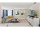 Open living room with a sectional sofa, area rug, and an entertainment center with a mounted TV at 4701 W Wyoming Ave, Tampa, FL 33616