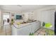 Bright living room with a sectional sofa, entertainment center with TV, and easy access to other rooms at 4701 W Wyoming Ave, Tampa, FL 33616