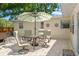 Backyard patio with brick pavers, outdoor seating and a green and white umbrella at 4701 W Wyoming Ave, Tampa, FL 33616