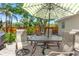 Inviting patio space with a dining table, umbrella, and views of the lush backyard at 4701 W Wyoming Ave, Tampa, FL 33616