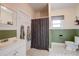 Bathroom features a neutral color scheme, tiled floors, and a shower with patterned curtain at 508 N Walker St, Plant City, FL 33563