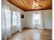 Well-lit bedroom with paneled wood ceiling, two windows, and light wood floors at 508 N Walker St, Plant City, FL 33563