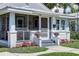Charming cottage-style home with a screened front porch, flowers and manicured lawn at 508 N Walker St, Plant City, FL 33563