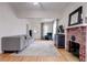 Open-concept living room with hardwood floors, a brick fireplace and a gray sofa at 508 N Walker St, Plant City, FL 33563