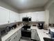 Well-lit kitchen with ample cabinet space, stainless steel microwave and quartz countertops at 527 Glenn Cross Dr, Ruskin, FL 33570