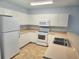 Bright kitchen featuring white appliances and tile flooring at 5303 Terraza Ct, Temple Terrace, FL 33617