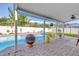 Covered outdoor patio overlooking the sparkling pool and meticulously landscaped yard, perfect for entertaining at 5925 18Th Ne St, St Petersburg, FL 33703
