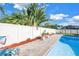 Fenced pool area featuring a landscaped brick-paved walkway and a lounge chair for poolside relaxation at 5925 18Th Ne St, St Petersburg, FL 33703