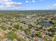 Aerial view of the neighborhood, showcasing lush trees, a pond, and various home styles at 5968 46Th N Ave, Kenneth City, FL 33709