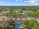 Aerial view of property with a pool in a neighborhood with lush trees and a road at 5968 46Th N Ave, Kenneth City, FL 33709
