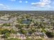Aerial view of a well-treed suburban neighborhood featuring a pond and various homes with pools at 5968 46Th N Ave, Kenneth City, FL 33709