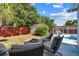 Outdoor patio with chairs and a small fire pit with lush green trees and a pool at 5968 46Th N Ave, Kenneth City, FL 33709
