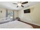 A cozy bedroom with a ceiling fan, TV, wood floors, and a crib by the window at 5968 46Th N Ave, Kenneth City, FL 33709