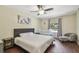 Bright bedroom featuring a queen bed, ceiling fan, and a crib by the window at 5968 46Th N Ave, Kenneth City, FL 33709
