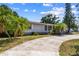 A quaint single-story home with mature landscaping, palm trees, and a spacious driveway at 5968 46Th N Ave, Kenneth City, FL 33709