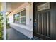 Welcoming home entrance with a black front door, security features, and a sunlit porch at 5968 46Th N Ave, Kenneth City, FL 33709
