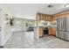 Open kitchen featuring stainless steel appliances, wood cabinetry, and an island bar at 5968 46Th N Ave, Kenneth City, FL 33709