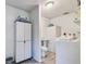 Cozy laundry room featuring modern appliances, a utility sink, storage cabinets, and wood-look flooring at 5968 46Th N Ave, Kenneth City, FL 33709