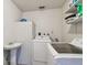 Bright laundry room with a utility sink, modern appliances, and shelving for organized storage at 5968 46Th N Ave, Kenneth City, FL 33709