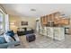 Inviting living room featuring tiled floors, comfortable seating, and a modern kitchen bar with stainless steel appliances at 5968 46Th N Ave, Kenneth City, FL 33709