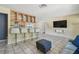 Open-concept living area with kitchen bar, tile floors, with mounted flatscreen and kitchen views at 5968 46Th N Ave, Kenneth City, FL 33709