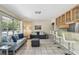 Bright and airy living room featuring tiled floors, comfortable seating, and a view to the kitchen bar at 5968 46Th N Ave, Kenneth City, FL 33709