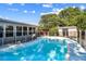 Backyard swimming pool surrounded by lush green trees, a white fence, and lounge chairs at 5968 46Th N Ave, Kenneth City, FL 33709