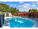 Backyard swimming pool with a safety fence, storage shed, and plenty of green trees at 5968 46Th N Ave, Kenneth City, FL 33709