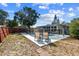 Backyard pool with lounge chairs and a security fence surrounded by green grass and mature trees at 5968 46Th N Ave, Kenneth City, FL 33709