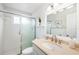 Clean bathroom with white tiled shower, updated vanity, brushed nickel fixtures, and decorative accents at 6075 Shore S Blvd # 215, Gulfport, FL 33707