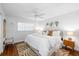 Bright bedroom with a comfy bed, wood floors, an earth tone rug, and beach-themed wall art at 6075 Shore S Blvd # 215, Gulfport, FL 33707