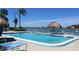 Inviting community pool featuring clear blue water, lounge chairs, and a tiki umbrella, perfect for relaxation at 6075 Shore S Blvd # 215, Gulfport, FL 33707