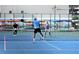 Active pickleball court featuring players enjoying the community sport, set against a colorful backdrop of kayaks at 6075 Shore S Blvd # 215, Gulfport, FL 33707