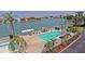 Community pool with tropical landscaping, lounge chairs, and water views, perfect for relaxation and leisure at 6075 Shore S Blvd # 215, Gulfport, FL 33707