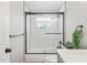 Clean bathroom featuring a tub with subway tile surround, glass door, and contemporary finishes at 6137 Halifax Dr, New Port Richey, FL 34653