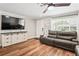 Cozy living room with hardwood floors, a ceiling fan, and natural light from the large window at 6137 Halifax Dr, New Port Richey, FL 34653