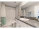 Bright bathroom featuring a shower-tub combo, granite counters and a modern vanity at 6180 Spring Crayfish Ave, New Port Richey, FL 34653