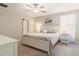 Cozy bedroom features a queen bed, soft gray tones, ceiling fan and bright window with flowing white curtains at 6180 Spring Crayfish Ave, New Port Richey, FL 34653